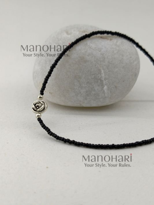 Naina Blossom Bead Anklet featuring elegant black bead detailing and a delicate floral charm in a silver replica design