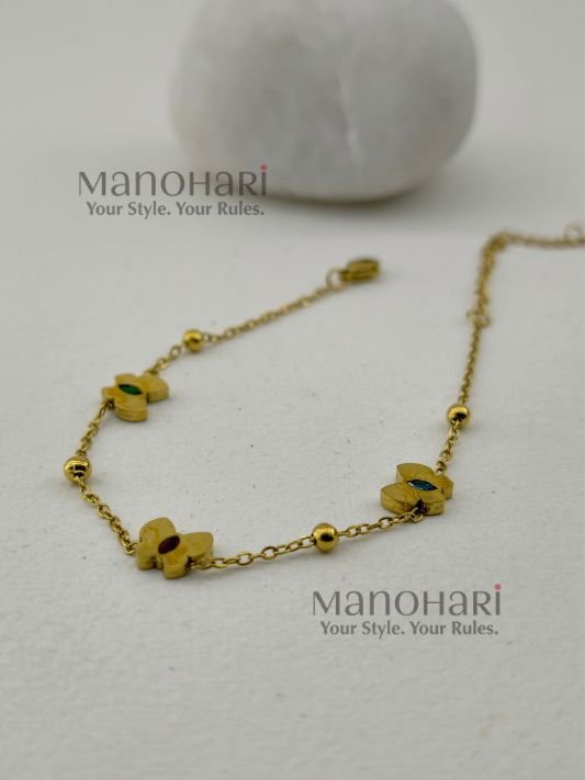 MN-BR-ACCB-AUR-01_1 Aurelia Clover Charm Bracelet featuring a delicate clover motif with sparkling multistone accents and an elegant anti-tarnish finish