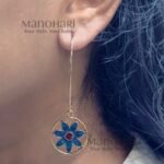 Meher Indigo Radiance Earrings featuring an indigo floral motif with a terracotta center framed within an elegant gold-tone circular design