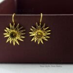 Meher Sunray Charm Hoops featuring a radiant sun-inspired charm crafted in raw brass with a classic hoop design