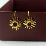 Meher Sunray Charm Hoops featuring a radiant sun-inspired charm crafted in raw brass with a classic hoop design