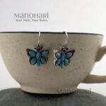 Naina Butterfly Bloom Earrings featuring a delicate butterfly design with stone accents and an elegant oxidised silver finish
