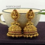 **Lakshmi Grace Kemp Jhumka crafted from premium brass with a matte gold polish, featuring a Goddess Lakshmi motif, clustered pearls, and traditional Kemp temple design for women.**