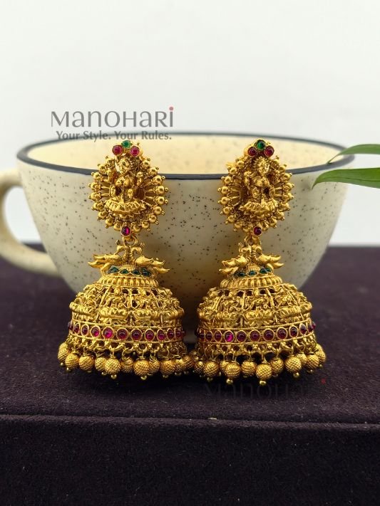 **Lakshmi Grace Kemp Jhumka crafted from premium brass with a matte gold polish, featuring a Goddess Lakshmi motif, clustered pearls, and traditional Kemp temple design for women.**