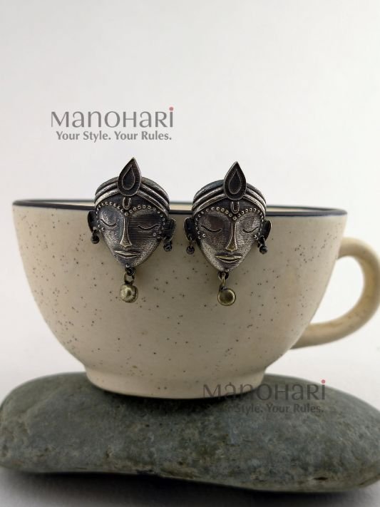 MN-ER-ZSES-ZIY-01_1 Ziya Silver Elegance Studs featuring an intricately carved divine face motif with an oxidised silver-tone finish and heritage-inspired craftsmanship