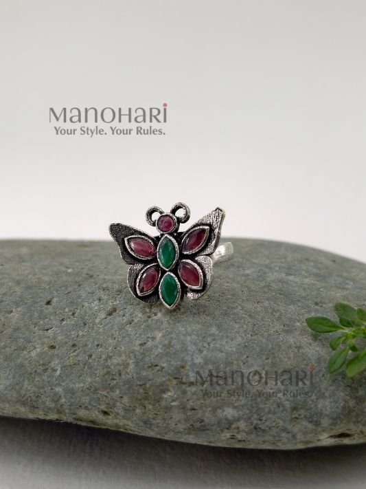 Ruhani butterfly jewel ring with red and green stones in an oxidised silver finish