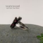 Ruhani butterfly jewel ring with red and green stones in an oxidised silver finish