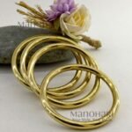 **Aarika Heritage Brass Bangles Set featuring four handcrafted premium brass bangles with a radiant golden finish, artisan detailing, and a classic 6 cm inner diameter for timeless ethnic elegance.**