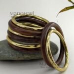 **The Vanya Rustic Wood Bangles Set showcases the timeless beauty of handcrafted wooden jewellery with a warm rustic brown finish accented by elegant gold-tone detailing. This set of **8 lightweight wooden bangles** is thoughtfully designed to offer both comfort and style, featuring an **inner diameter of approximately 6 cm** for a comfortable fit. Perfect for stacking or wearing individually, these versatile bangles effortlessly complement **Kerala Kasavu sarees, cotton sarees, silk sarees, kurtis, dresses, and Indo-western outfits**. Ideal for **Onam, weddings, festivals, office wear, casual outings, cultural celebrations, and everyday styling**, the **Vanya Rustic Wood Bangles Set** adds a touch of natural elegance to every look. Exclusively curated by **Manohari Style**, this beautifully crafted bangle set blends rustic charm, modern versatility, and timeless craftsmanship, making it a must-have accessory for every woman's jewellery collection.**