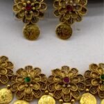 **Gauri Coin Heritage Choker Set crafted from premium alloy with a radiant gold-plated finish, featuring traditional coin work, sparkling artificial stones, and matching earrings with an adjustable thread for women.**