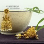 **Aadhira Antique Elegance Earrings crafted from premium brass metal with a radiant High Gold Polished finish, featuring an elegant antique-inspired design adorned with artificial stones for women.**