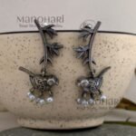**Avira Bird Leaf Earrings crafted from pure brass with an elegant silver replica finish, featuring an intricate bird and leaf design adorned with delicate glass pearl beads for a graceful nature-inspired look.**