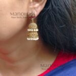 **Mrunalini Pearl Heritage Jhumka crafted from premium copper and brass metal alloy with a radiant high gold polish, featuring elegant clustered pearls and heritage-inspired jhumka design for women.**