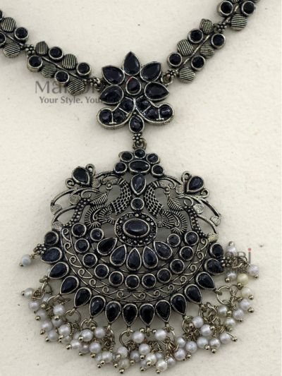 **Varnika Floral Pearl Heritage Necklace crafted from premium brass with a silver replica finish, featuring an intricate floral pendant adorned with elegant black stones, measuring 6 × 5 cm on a 21 cm statement necklace for timeless ethnic elegance.**