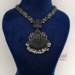 **Varnika Floral Pearl Heritage Necklace crafted from premium brass with a silver replica finish, featuring an intricate floral pendant adorned with elegant black stones, measuring 6 × 5 cm on a 21 cm statement necklace for timeless ethnic elegance.**