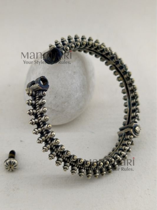 MN-BG-SLV-AVS-01_2 **Aaranya Vintage Silver Bangle crafted from premium brass with a refined silver-plated finish, featuring a vintage-inspired openable design and a comfortable 5.5 cm inner diameter for timeless ethnic elegance.**