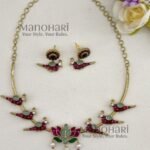 Kavya Jadau Meenakari Lotus Hasli Choker Set features an elegant lotus-inspired design with traditional Jadau and Meenakari detailing, crafted in brass with a Kundan extension chain and convenient push-button clasp. Perfect for weddings, Onam, festivals and special occasions, this statement choker beautifully complements sarees, lehengas and ethnic outfits.