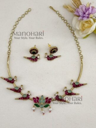 Kavya Jadau Meenakari Lotus Hasli Choker Set features an elegant lotus-inspired design with traditional Jadau and Meenakari detailing, crafted in brass with a Kundan extension chain and convenient push-button clasp. Perfect for weddings, Onam, festivals and special occasions, this statement choker beautifully complements sarees, lehengas and ethnic outfits.