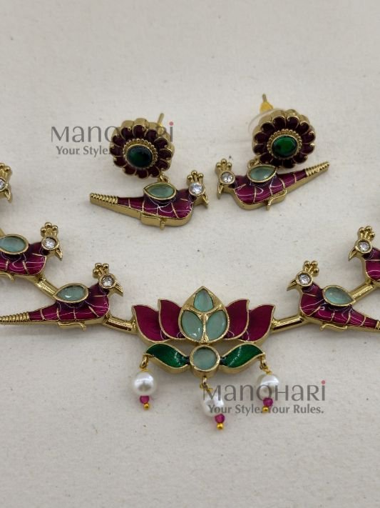 Kavya Jadau Meenakari Lotus Hasli Choker Set features an elegant lotus-inspired design with traditional Jadau and Meenakari detailing, crafted in brass with a Kundan extension chain and convenient push-button clasp. Perfect for weddings, Onam, festivals and special occasions, this statement choker beautifully complements sarees, lehengas and ethnic outfits.