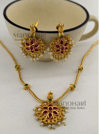 **The Meher Antique Kemp Necklace Set is a timeless celebration of South Indian heritage, crafted from **premium brass** with a luxurious **matte gold-plated finish**. Embellished with vibrant **traditional Kemp stones**, this elegant necklace showcases intricate temple-inspired craftsmanship that radiates regal charm. The **21 cm necklace** features an **adjustable extension chain** for a comfortable fit, while the matching **4.5 cm earrings** complete the coordinated look. Perfectly paired with **Kerala Kasavu sarees, Kanchipuram silk sarees, lehengas, Anarkalis, and other traditional attire**, this exquisite jewellery set is ideal for **Onam, weddings, temple visits, engagements, receptions, festivals, and bridal celebrations**. Exclusively curated by **Manohari Style**, the **Meher Antique Kemp Necklace Set** combines heritage artistry, premium craftsmanship, and timeless elegance, making it a treasured addition to every woman's ethnic jewellery collection.**