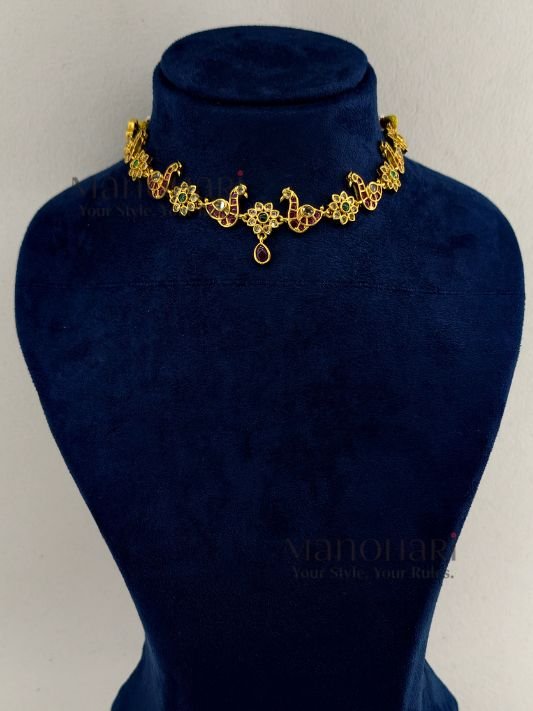 **Morika Peacock Heritage Necklace crafted from a premium alloy metal base with a luxurious gold-plated antique finish, adorned with vibrant Kemp-inspired stones, AD/CZ accents, Kundan-style detailing, pearls, and decorative beads, featuring an elegant peacock motif with matching earrings for timeless bridal and festive elegance.**