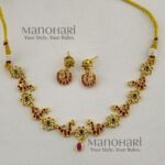 **Morika Peacock Heritage Necklace crafted from a premium alloy metal base with a luxurious gold-plated antique finish, adorned with vibrant Kemp-inspired stones, AD/CZ accents, Kundan-style detailing, pearls, and decorative beads, featuring an elegant peacock motif with matching earrings for timeless bridal and festive elegance.**