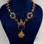 **Aadhira Heritage Polki Necklace Set featuring an antique gold-plated finish, a stunning Labradorite-inspired centre stone, vibrant multicoloured Polki-style embellishments, an elegant 18.5 cm floral necklace, and matching 6 cm statement earrings for timeless bridal and festive elegance.**