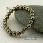 Aadhya Pyrite Luxe Crystal Bracelet featuring hand-picked natural pyrite stones with a striking metallic golden shine in a stretch bracelet design.
